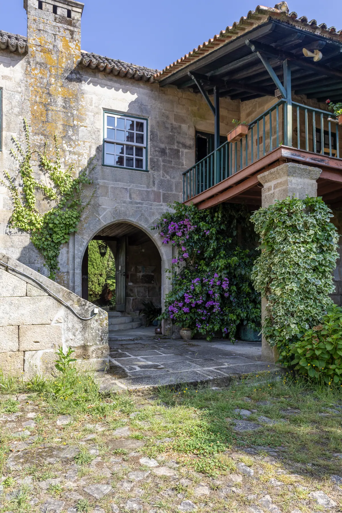 Portal de pedra da Quinta da Comenda coberto de flores